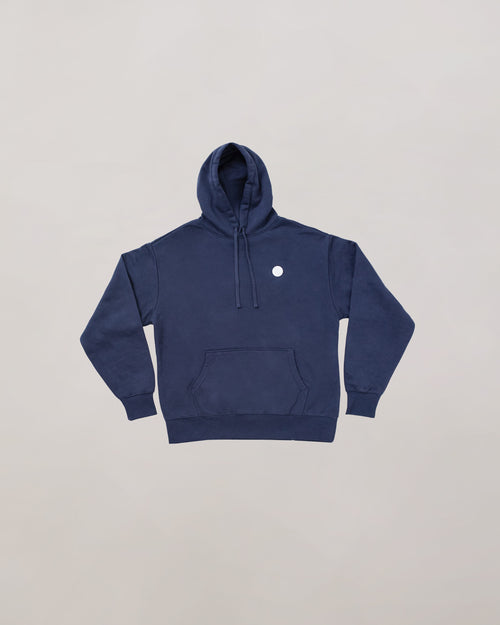 Navy blue hoodie with a small white logo on a light gray background