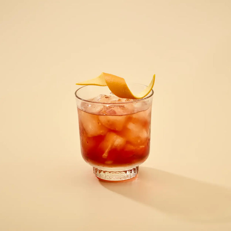 Cocktail with an orange twist on a beige background