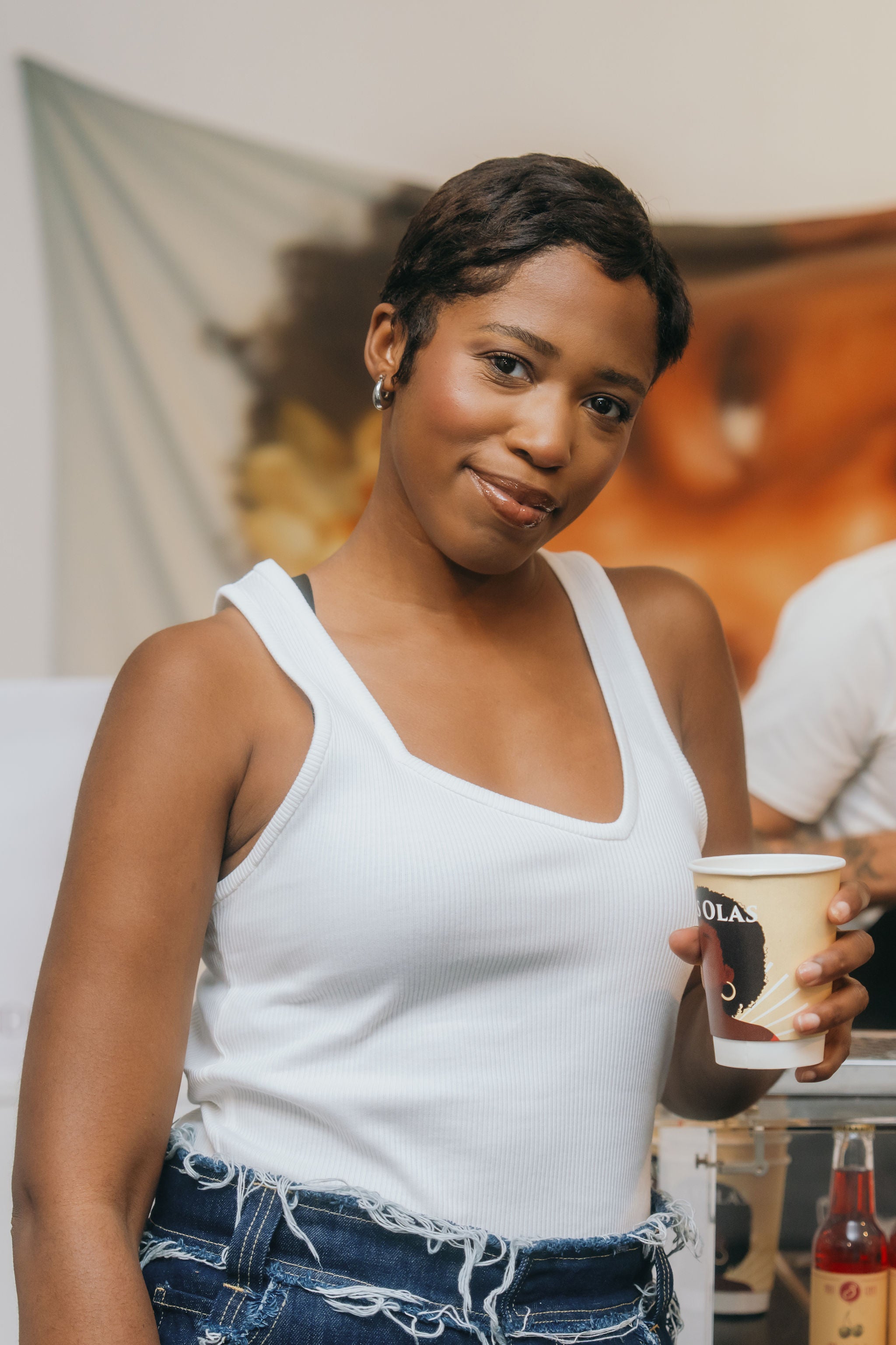 Woman holding a las olas cup in a casual setting