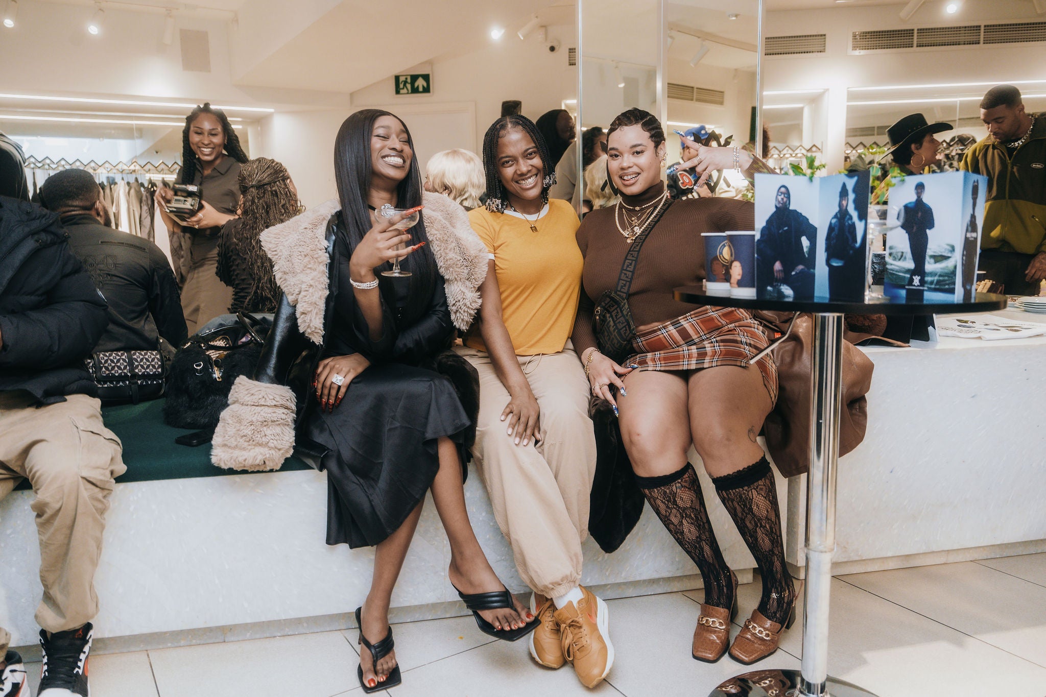 Group of women sitting together in a store, smiling and posing for a photo.