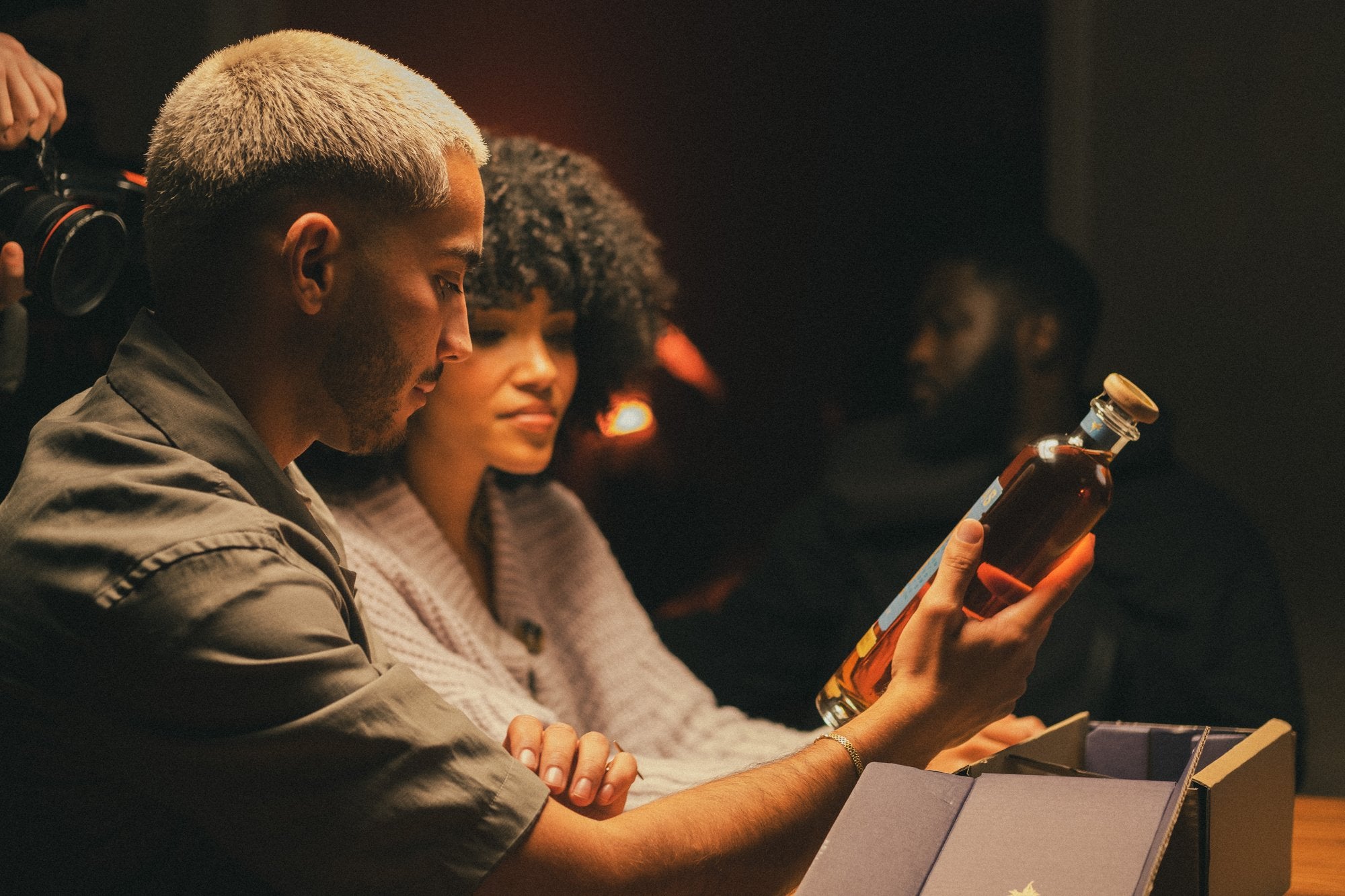 Two people looking closely at a bottle of Las Olas